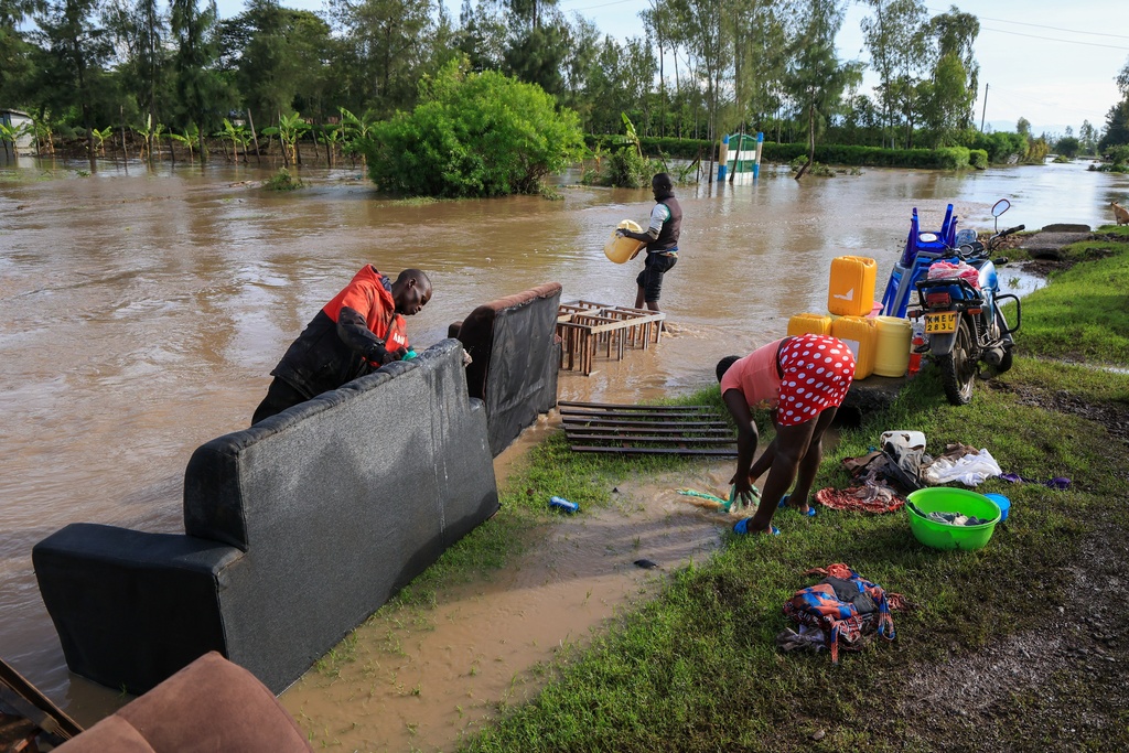 People wash their belongings spoiled by flood waters following heavy rains in Ahero, Western Kenya, Tuesday, March 24, 2026. (AP Photo/Andrew Kasuku)