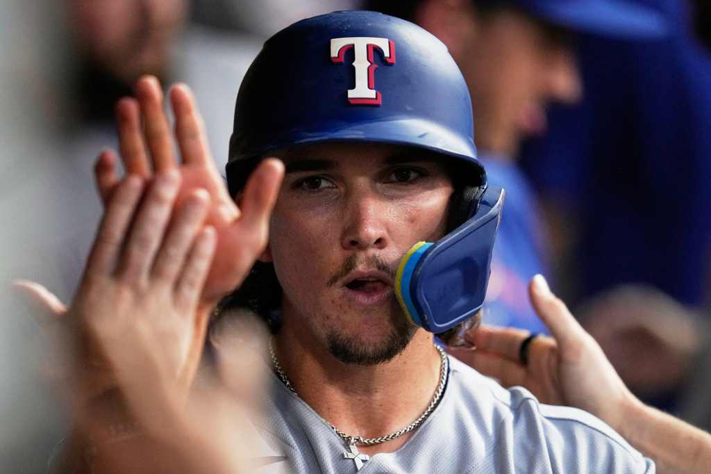 Texas Rangers' Cameron Cauley celebrates in the dugout after scoring in the seventh inning of a baseball game against the Cleveland Guardians in Cleveland, Monday, June 29, 2026. (AP Photo/Sue Ogrocki)