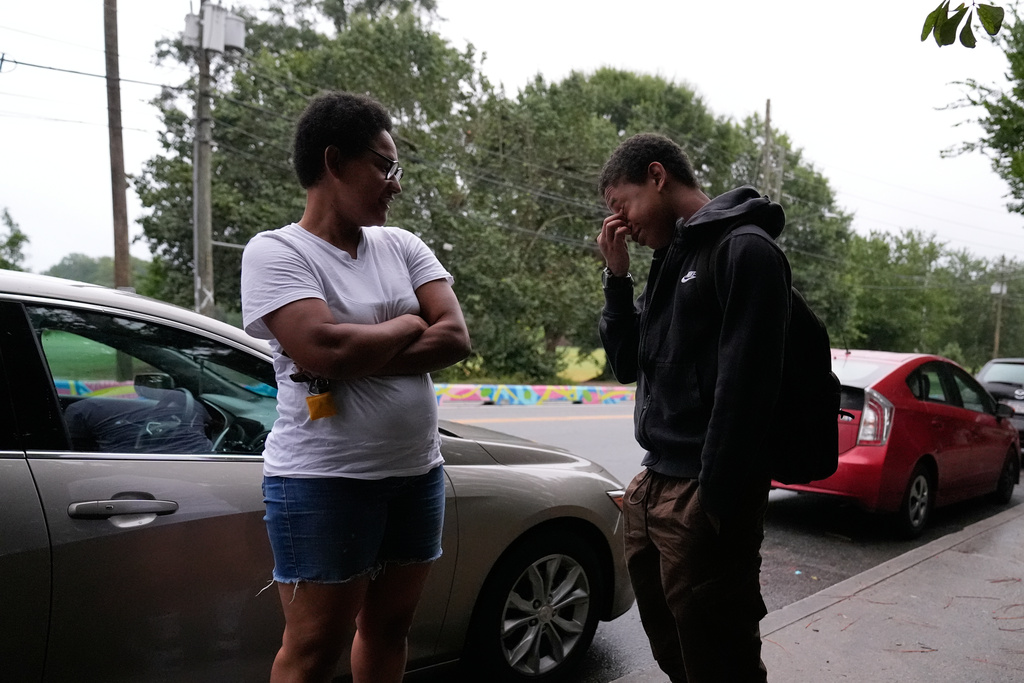 Sechita McNair, left, talks to her oldest son, Elias Washington before he walks into Midtown High School for the first day of school on Aug. 4, 2025, in Atlanta. (AP Photo/Brynn Anderson)