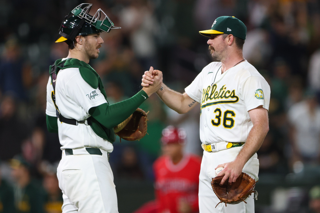 Athletics' Hogan Harris (36) celebrates with teammate Jonah Heim, left, after the Athletics win over the Los Angeles Angels in a baseball game Tuesday, Sept. 22, 2026, in West Sacramento, Calif. (AP Photo/Scott Marshall)
