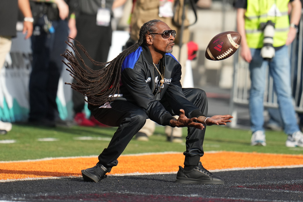 Snoop Dogg tries to make the catch on a kick off in the first half of the Snoop Dogg Arizona Bowl NCAA college football game between Fresno State and Miami, Saturday, Dec. 27, 2025, in Tucson, Ariz. (AP Photo/Rick Scuteri)