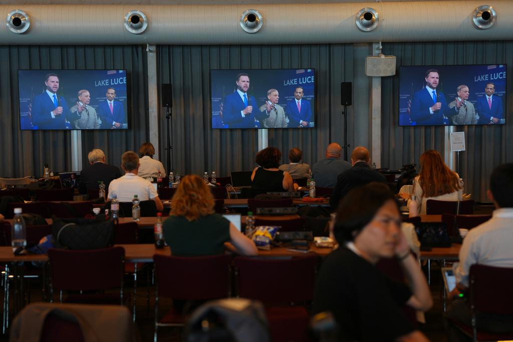 Members of the media watch screens broadcasting the Iran US negotiations and showing U.S. Vice President JD Vance, Pakistan's Prime Minister Shehbaz Sharif, and Qatar's Prime Minister and Foreign Minister Sheikh Mohammed bin Abdulrahman Al Thani, at the Burgenstock Resort in Obbuergen, near Lucerne, in Switzerland, Sunday, June 21, 2026. (AP Photo/Vadim Ghirda)