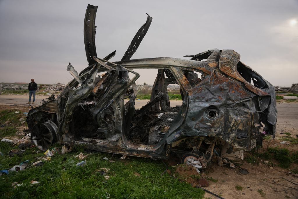 A man stands next to an Egyptian committee's vehicle that was hit by an Israeli strike, killing three Palestinian journalists, in Zahraa, central Gaza Strip, Wednesday, Jan. 21, 2026. (AP Photo/Abdel Kareem Hana)