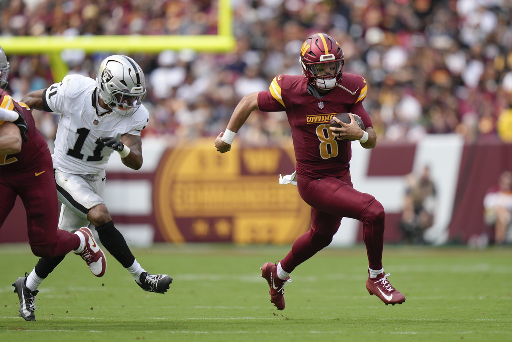 Washington Commanders quarterback Marcus Mariota (8) runs with the ball during the first half of NFL football game against the Las Vegas Raiders, Sunday, Sept. 21, 2025, in Landover, Md. (AP Photo/Stephanie Scarbrough)