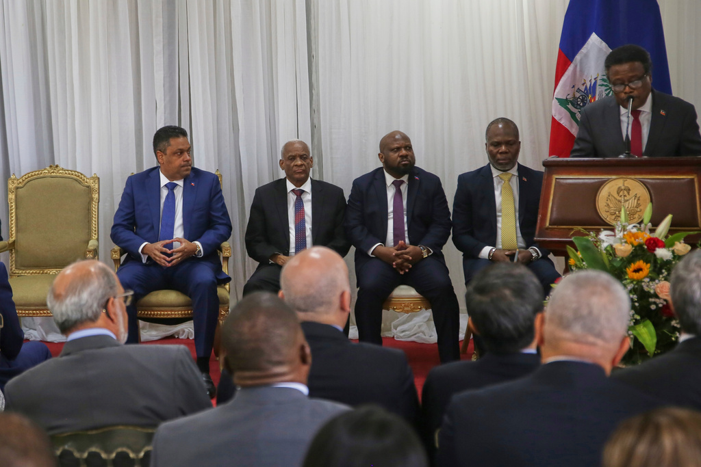 Outgoing president of the transitional council Fritz Alphonse Jean, right, speaks during a ceremony to name Laurent Saint-Cyr, center, as the new council president in Port-au-Prince, Haiti, Thursday, Aug. 7, 2025. (AP Photo/Odelyn Joseph)