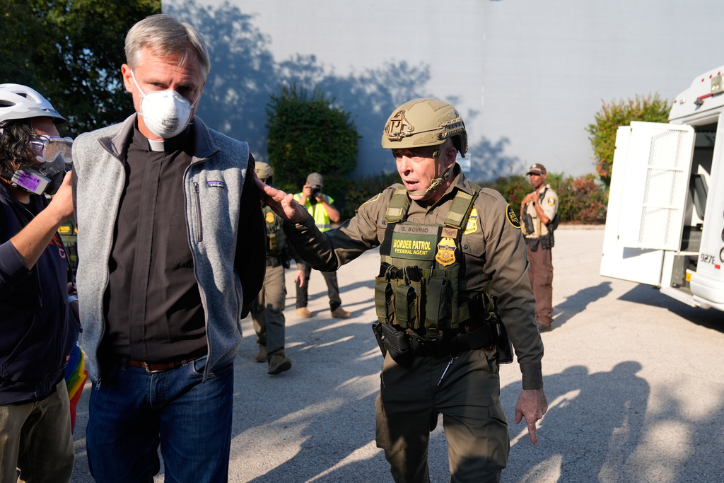 Greg Bovino, the chief patrol agent for the U.S. Border Patrol El Centro sector, right, walks along protester that was detained near an Immigration and Customs Enforcement facility in Broadview, Ill., Friday, Oct. 3, 2025. (AP Photo/Erin Hooley)