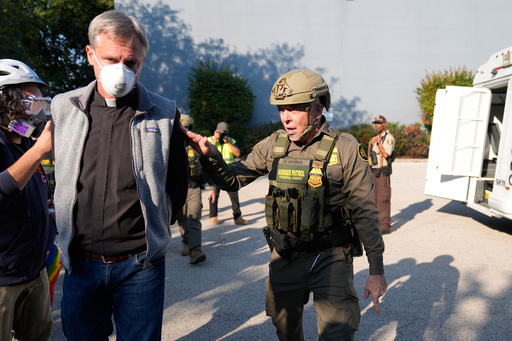 RETRANSMITTING TO REMOVE REFERENCE TO PROTESTER BEING DETAINED. HE WAS WALKING WITH HIS HANDS BEHIND HIS BACK Greg Bovino, the chief patrol agent for the U.S. Border Patrol El Centro sector, right, walks along a protester with his hands behind his back near an Immigration and Customs Enforcement facility in Broadview, Ill., Friday, Oct. 3, 2025. (AP Photo/Erin Hooley) RETRANSMITTING TO REMOVE REFERENCE TO PROTESTER BEING DETAINED. HE WAS WALKING WITH HIS HANDS BEHIND HIS BACK Greg Bovino, the chief patrol agent for the U.S. Border Patrol El Centro sector, right, walks along a protester with his hands behind his back near an Immigration and Customs Enforcement facility in Broadview, Ill., Friday, Oct. 3, 2025. (AP Photo/Erin Hooley)