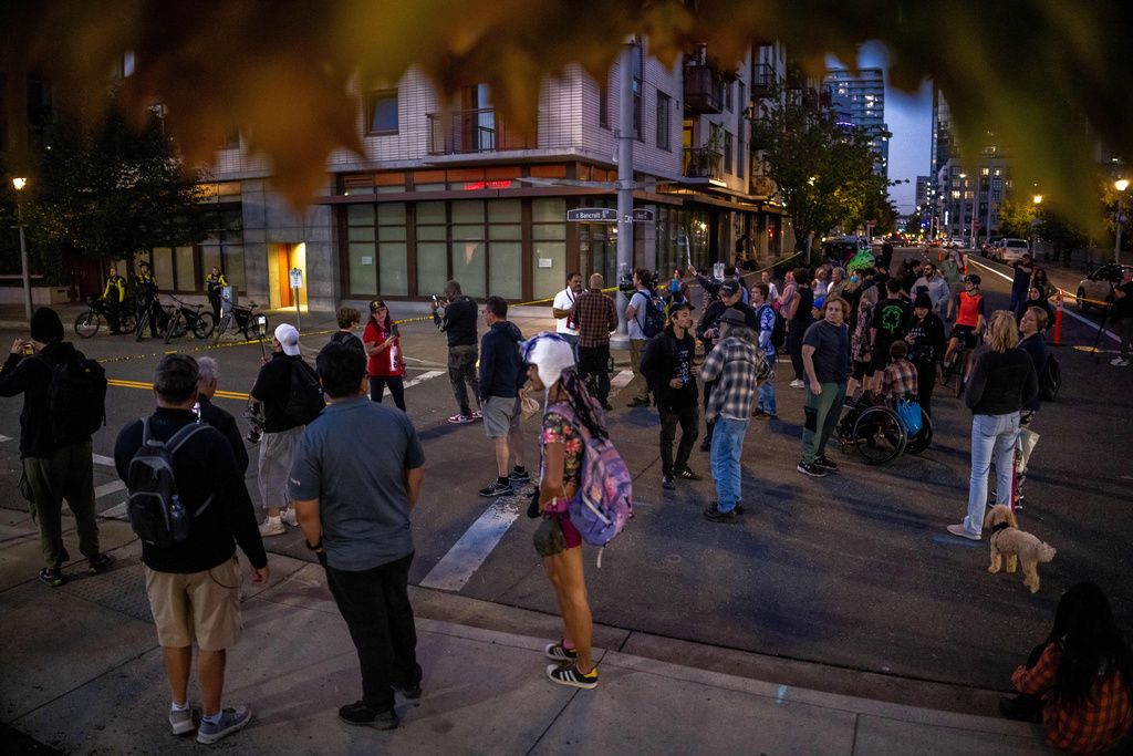 Demonstrators stand outside a U.S. Immigration and Customs Enforcement facility on Tuesday, Oct. 7, 2025, in Portland, Ore. (AP Photo/Ethan Swope)