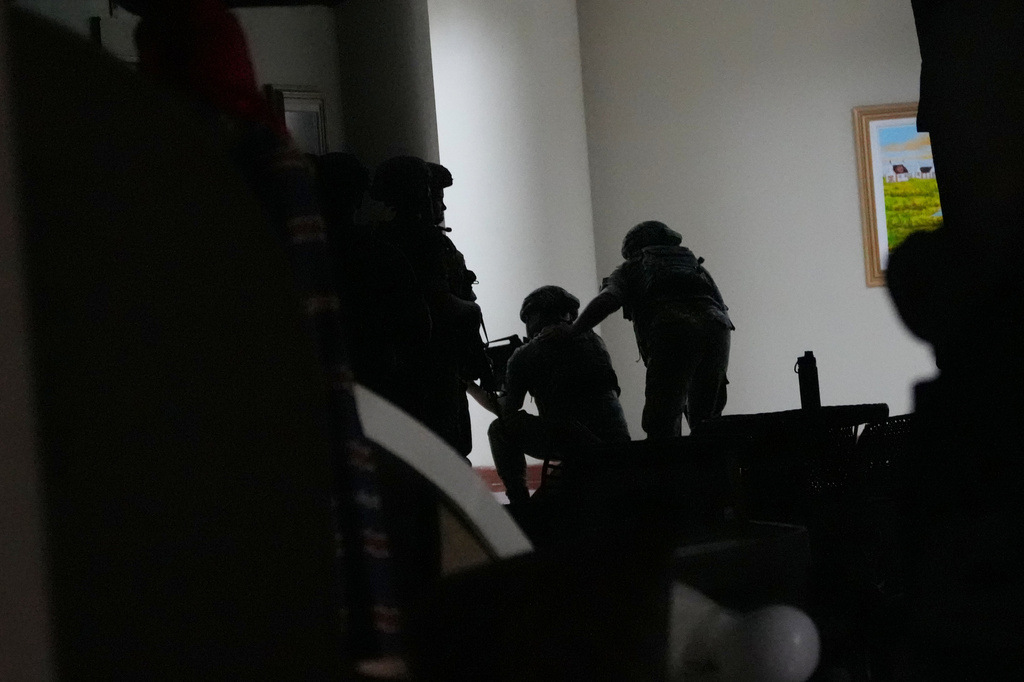 Philippine troopers exchange fire along a hallway at the Philippine Senate in Pasay, Philippines on Wednesday May 13, 2026. (AP Photo/Aaron Favila)