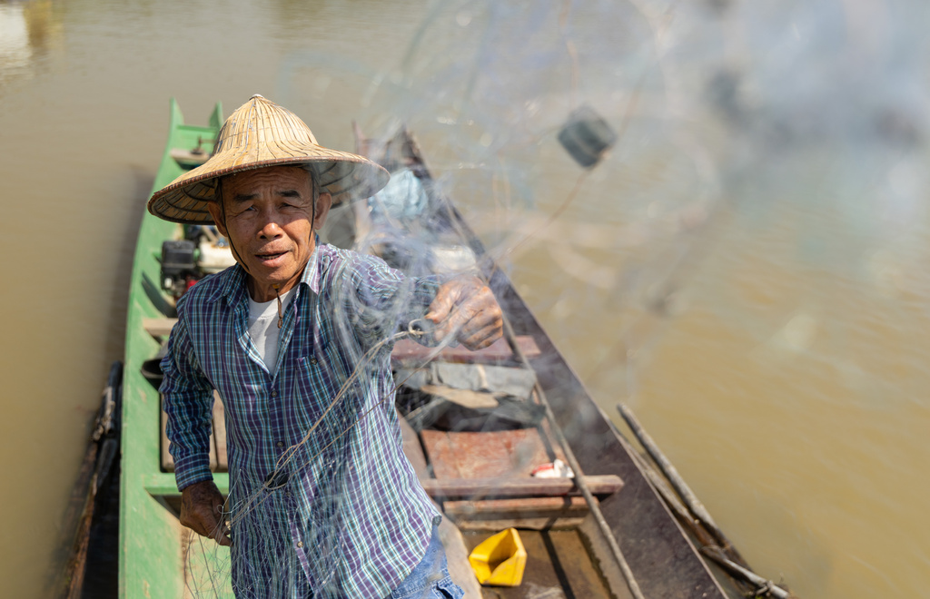 Fisherman Sukjai Yana untangles his net while docked on the Kok River in Chiang Saen, Thailand, on Feb. 17, 2026. (AP Photo/Anton L. Delgado)