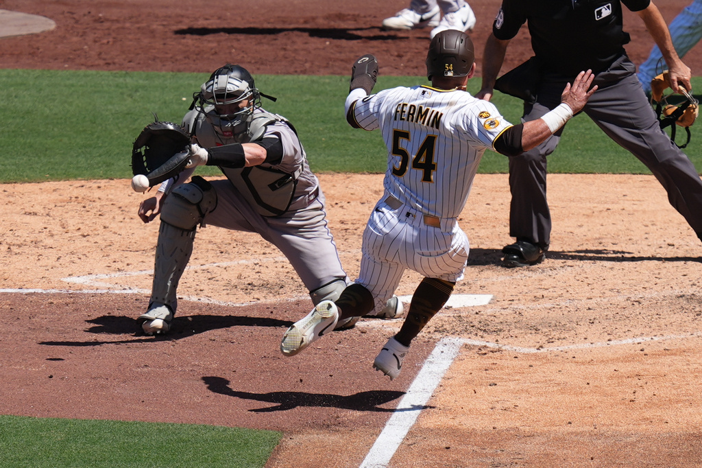 Colorado Rockies catcher Brett Sullivan, left, waits for the throw before tagging out San Diego Padres' Freddy Fermin (54), trying to score from third during the fifth inning of a baseball game Wednesday, July 29, 2026, in San Diego. (AP Photo/Gregory Bull)