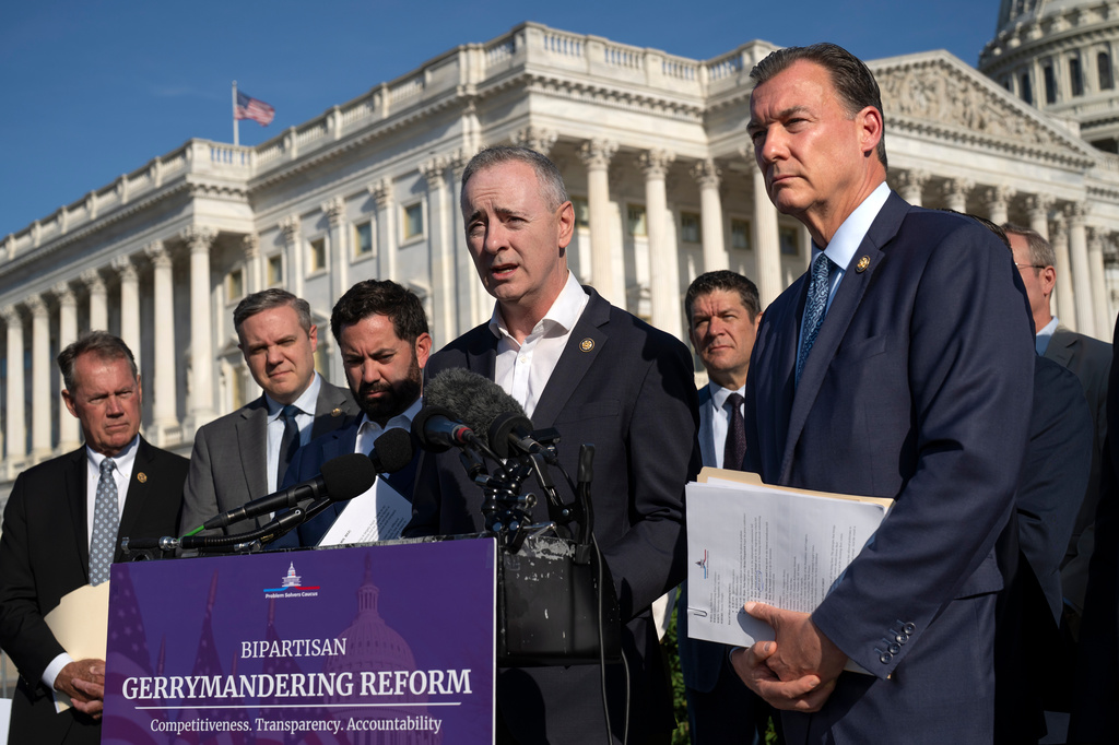 Rep. Brian Fitzpatrick, R-Pa., center, and Rep. Tom Suozzi, D-N.Y., right, talk to reporters about partisan gerrymandering, the reshaping of congressional districts to benefit one political party, during a news conference at the Capitol in Washington, Wednesday, Sept. 16, 2026. (AP Photo/J. Scott Applewhite)