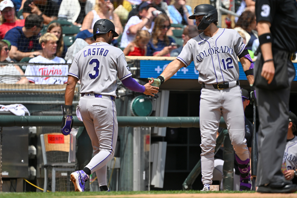 Colorado Rockies' Willi Castro (3) celebrates with Kyle Karros (12) after scoring on a TJ Rumfield single against the Minnesota Twins during the first inning of a baseball game Sunday, June 28, 2026, in Minneapolis. (AP Photo/Craig Lassig)