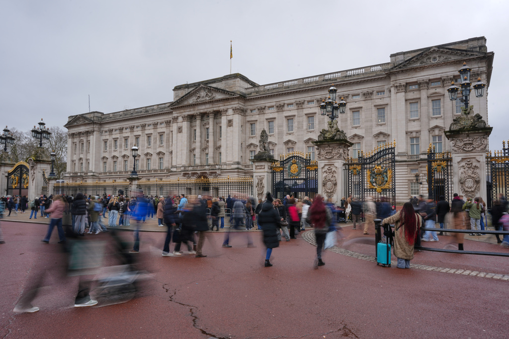 Visitors stand at the gates of Buckingham Palace in London, Thursday, Feb. 19, 2026 after Andrew Mountbatten-Windsor has been arrested by British police on suspicion of misconduct in public office. (AP Photo/Kin Cheung)