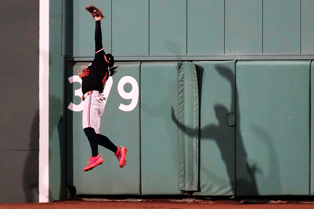 Minnesota Twins center fielder Austin Martin leaps to catch a flyout hit by Boston Red Sox's Caleb Durbin during the sixth inning of a baseball game, Friday, May 22, 2026, in Boston. (AP Photo/Charles Krupa)