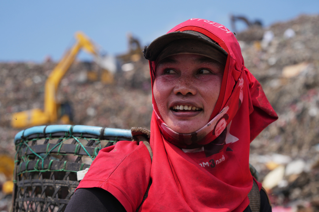 Nur Wencih, a waste picker, walks past at the Bantargebang landfill on the outskirts of Jakarta, Indonesia, Monday, July 6, 2026. (AP Photo/Tatan Syuflana)