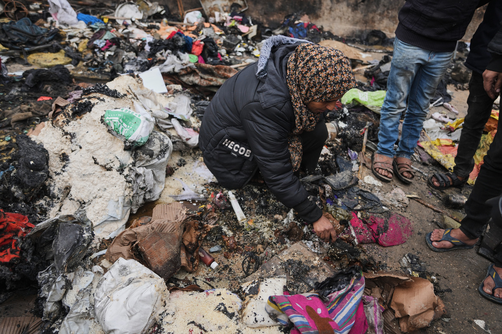 Fatima Abu al-Bayd inspects what remains of her mother's tent after her mother, Amal Abu Al-Khair, and grandchild, Saud, were killed when it caught fire overnight at the Yarmouk displacement camp in Gaza City, Friday, Jan. 2, 2026. (AP Photo/Jehad Alshrafi)