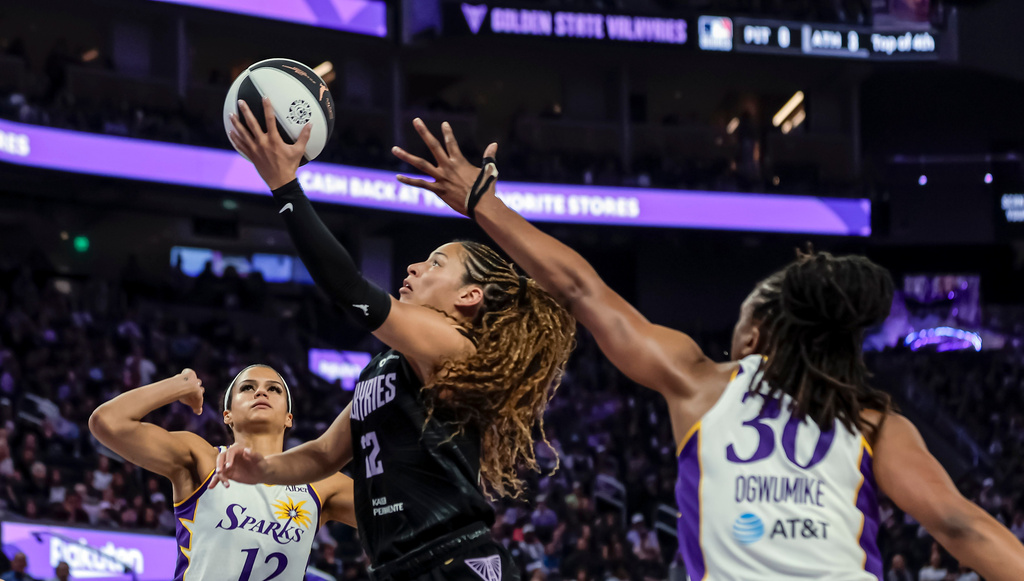 Golden State Valkyries' Veronice Burton, center, goes up to shoot between Los Angeles Sparks' Nneka Ogwumike (30) and Rae Burrell (12) in the first half of a WNBA basketball game Monday, June 15, 2026, in San Francisco. (Carlos Avila Gonzalez/San Francisco Chronicle via AP)