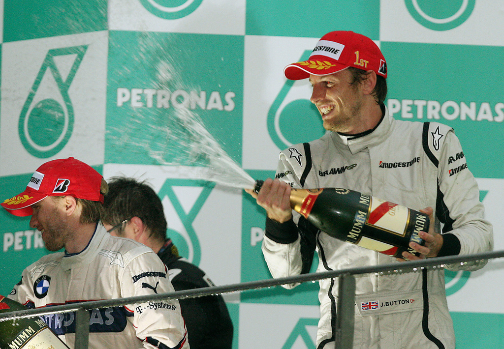 FILE - Brawn GP Formula One driver Jenson Button of Britain, right, BMW Sauber Formula One driver Nick Heidfeld of Germany celebrate during the award ceremony of the Malaysia Formula One Grand Prix at the Sepang racetrack in Kuala Lumpur, Sunday, April 5, 2009. (AP Photo/Eugene Hoshiko, File)