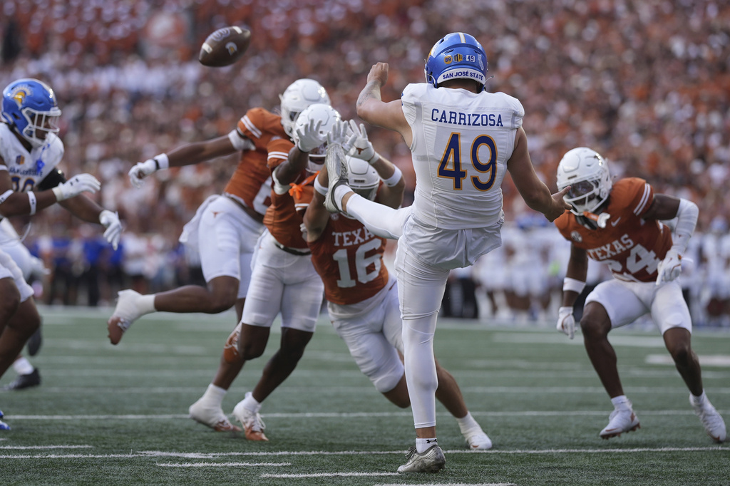 San Jose State punter Trent Carrizosa (49) is pressured by the Texas defense on a punt during the first half of an NCAA college football game in Austin, Texas, Saturday, Sept. 6, 2025. (AP Photo/Eric Gay)