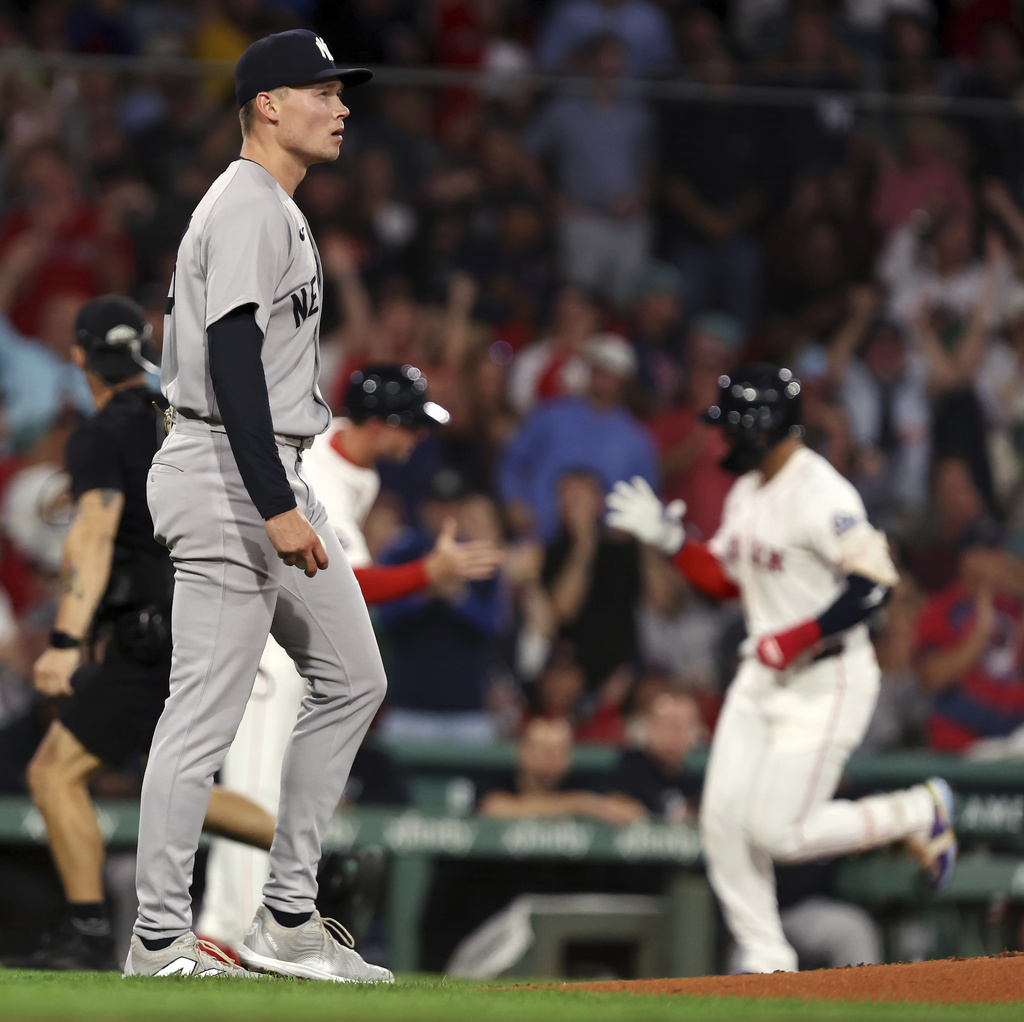 Boston Red Sox's Carlos Narvaez, back right, rounds third base after hitting a solo home run in the bottom of the first inning off New York Yankees tarting pitcher Will Warren, front left, in the first inning of a baseball game Sunday, Sept. 14, 2025, in Boston. (AP Photo/Jim Davis)