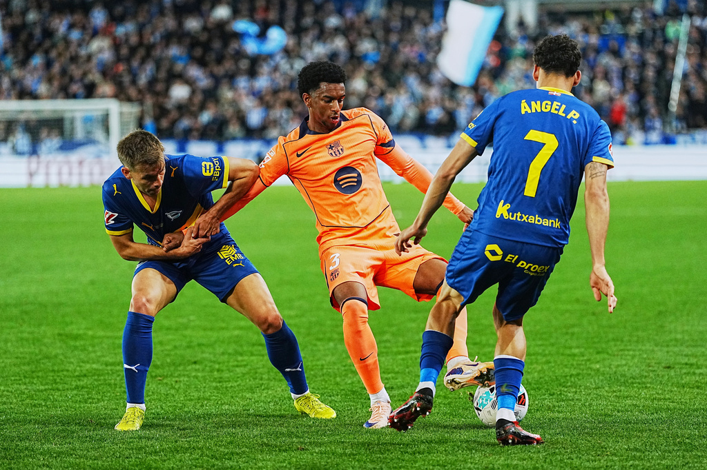 Barcelona's Alejandro Balde, center, fights for the ball with Alaves' Angel Perez, right, and Antonio Blanco during the Spanish La Liga soccer match between Alaves and Barcelona in Vitoria-Gasteiz, Spain, Wednesday, May 13, 2026. (AP Photo/Miguel Oses)