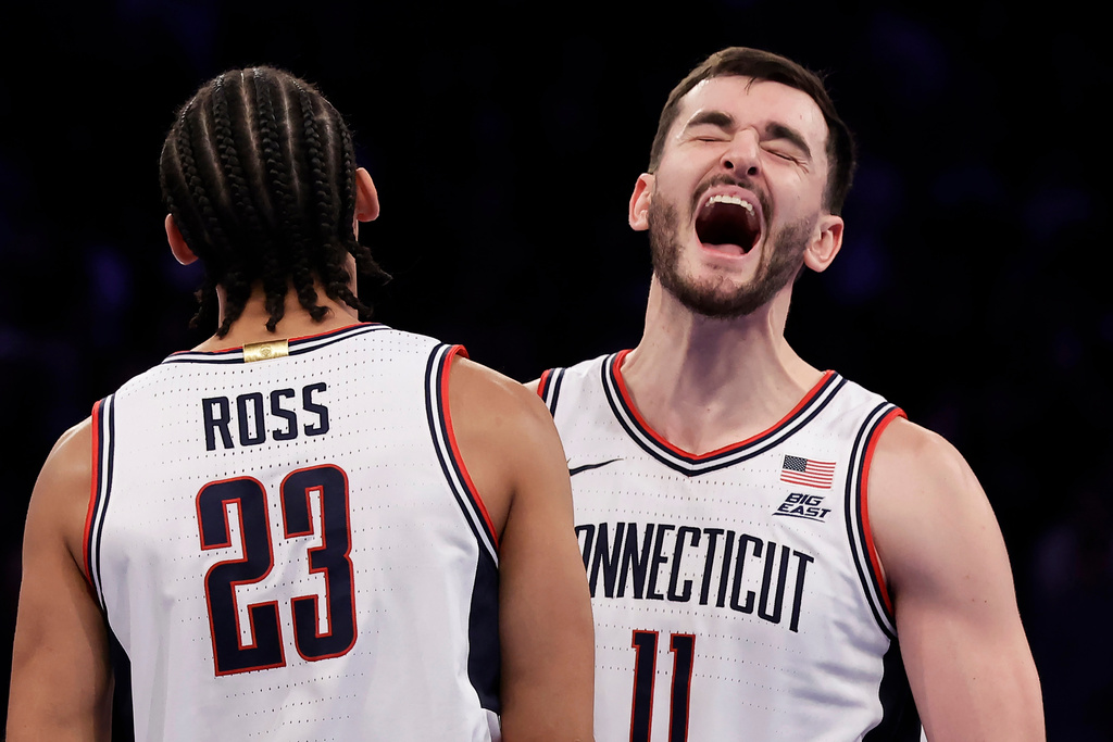 UConn forward Alex Karaban (11) and Jayden Ross (23) celebrate after defeating Illinois in an NCAA college basketball game Friday, Nov. 28, 2025, in New York. (AP Photo/Adam Hunger)