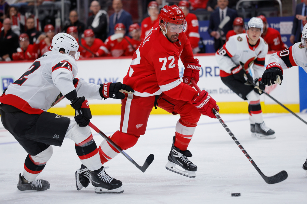 Detroit Red Wings center Dylan Larkin (71) drives the puck past Ottawa Senators defenseman Thomas Chabot, left, to score during the second period of an NHL hockey game Tuesday, Oct. 6, 2026, in Detroit. (AP Photo/Duane Burleson)