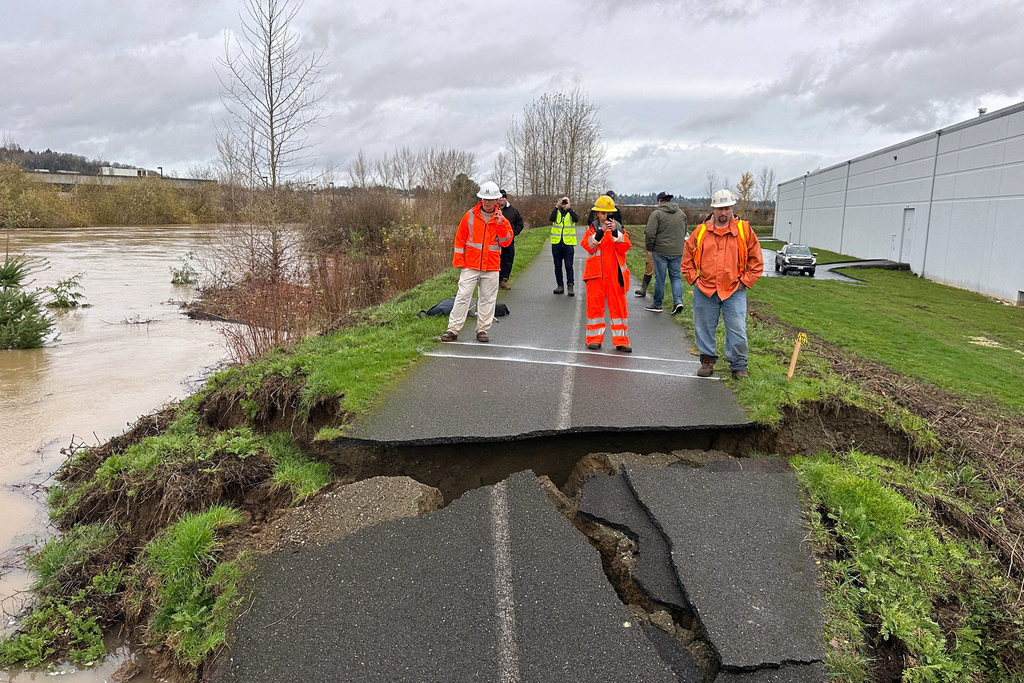 Crews inspect a crack in a levee along the Green River in Tukwila, Wash., Monday, Dec. 15, 2025. (AP Photo/Manuel Valdes)
