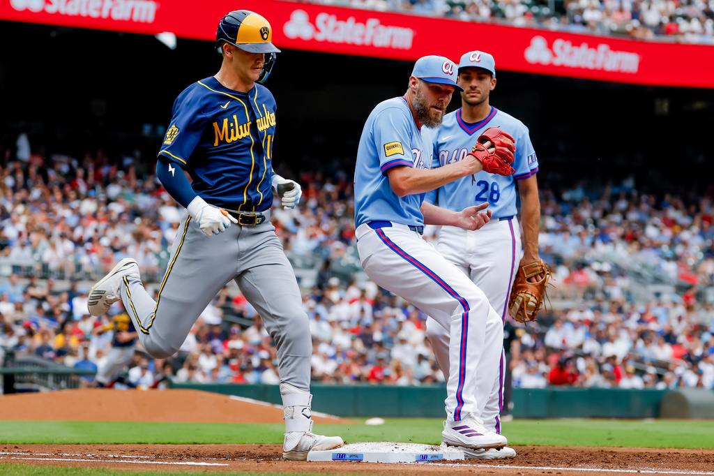 Atlanta Braves pitcher Chris Sale, front right, beats Milwaukee Brewers' Cooper Pratt, left, to first base for a groundout during the second inning of a baseball game, Saturday, June 20, 2026, in Atlanta. (AP Photo/Erik S. Lesser)