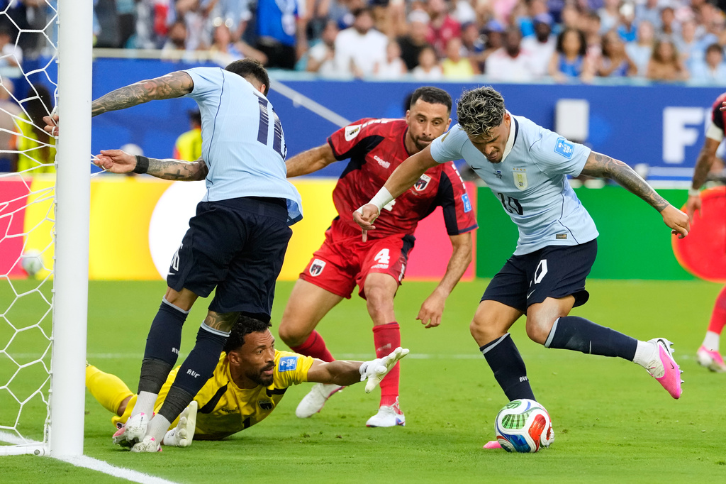 Uruguay's Maxi Araujo (20) attempts a shot on goal as Cape Verde goalkeeper Vozinha (1) reaches out for the ball during the World Cup Group H soccer match between Uruguay and Cape Verde in Miami Gardens, Fla., Sunday, June 21, 2026. (AP Photo/Rebecca Blackwell)