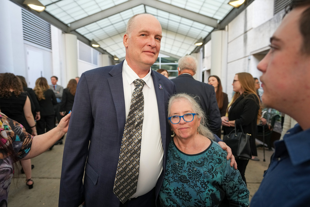 FILE - Michael Scott, left, hugs Sharon Shipman, the mother of yogurt shop suspect Forrest Welborn, after he was exonerated at a hearing for four men wrongfully accused in the 1991 Austin yogurt shop murders at the Blackwell-Thurman Criminal Justice Center in Austin, Texas, Feb. 19, 2026. (Jay Janner/Austin American-Statesman via AP, File)
