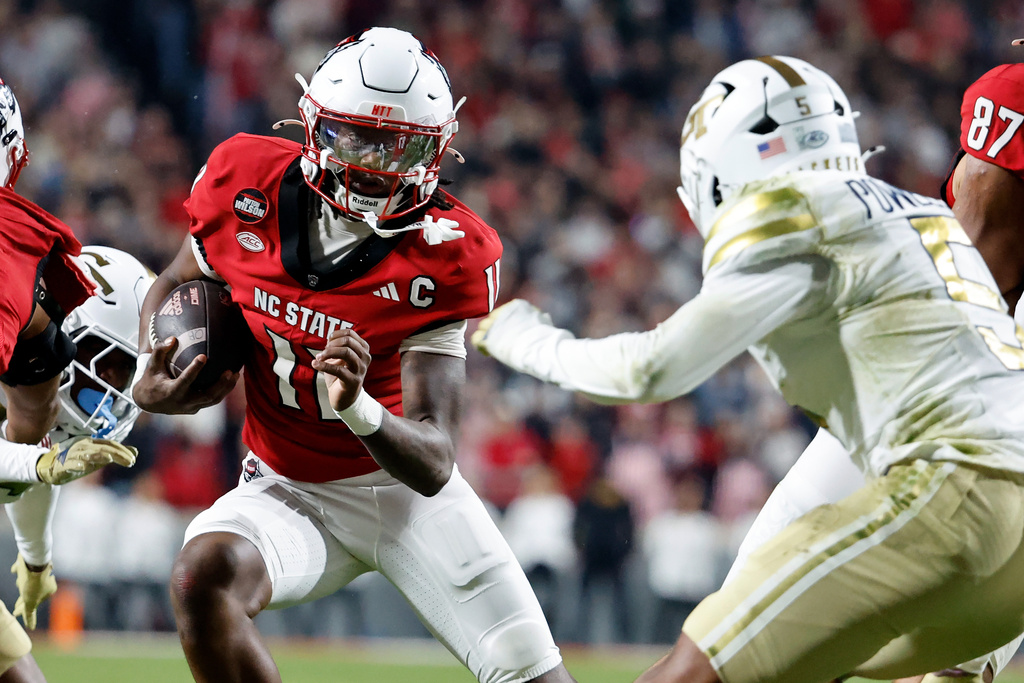 North Carolina State quarterback CJ Bailey (11) runs the ball as Georgia Tech's Clayton Powell-Lee (5) closes in during the first half of an NCAA college football game in Raleigh, N.C., Saturday, Nov. 1, 2025. (AP Photo/Karl DeBlaker)