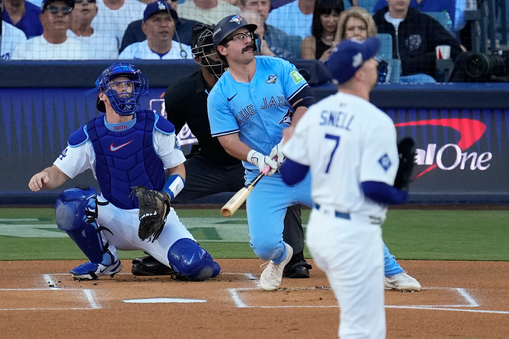 Toronto Blue Jays' Davis Schneider watches his solo home run off Los Angeles Dodgers pitcher Blake Snell (7) leave the park during the first inning in Game 5 of baseball's World Series, Wednesday, Oct. 29, 2025, in Los Angeles. (AP Photo/David J. Phillip)