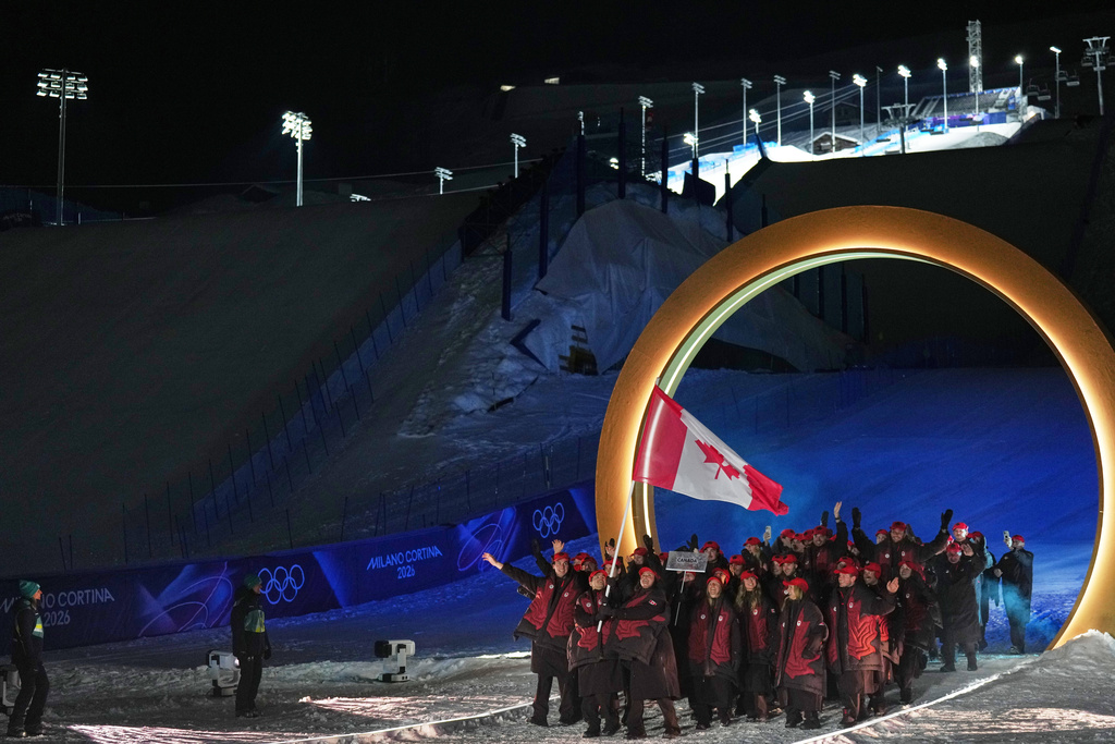 Marielle Thompson and Mikael Kingsbury, flag bearers of Canada walk with athletes during the Olympic opening ceremony at the 2026 Winter Olympics, in Livigno, Italy, Friday, Feb. 6, 2026. (AP Photo/Abbie Parr)