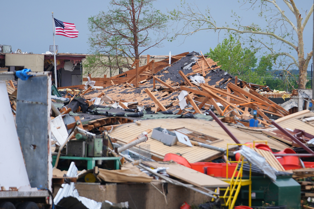A United States flag waves over debris following a storm in Mineral Wells, Texas, Wednesday, April 29, 2026. (AP Photo/Julio Cortez)