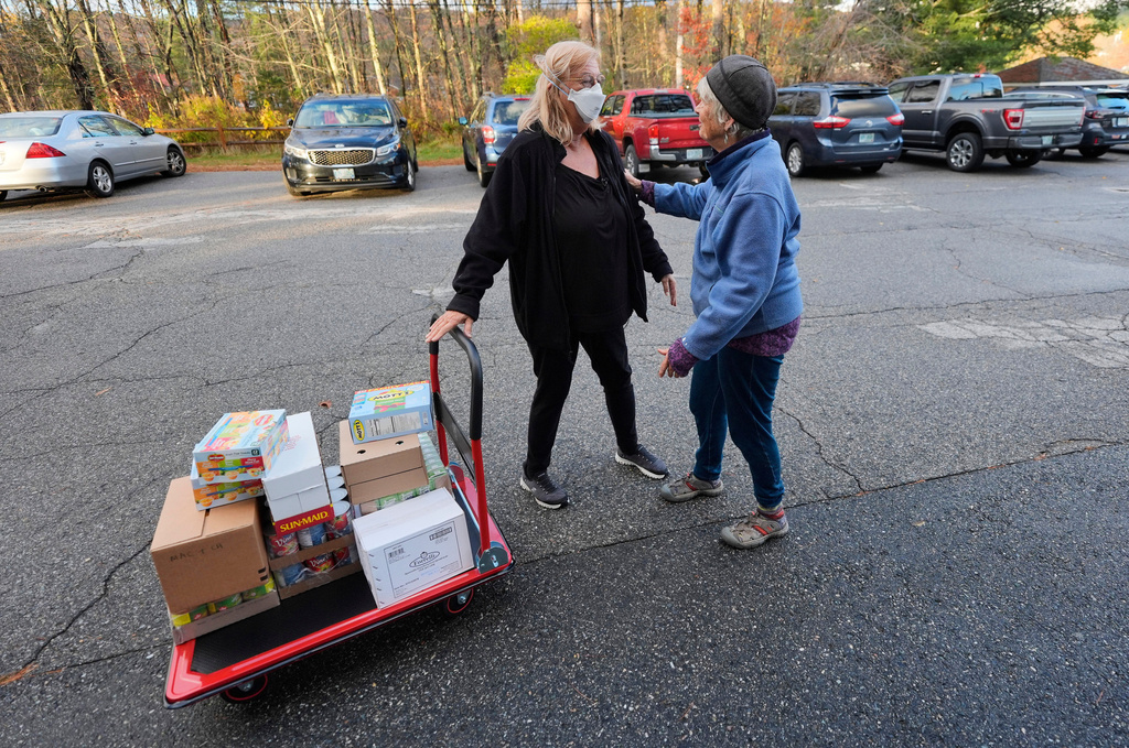 Marsha Luce, left, a patient at Ammonoosuc Community Health Services clinic, speaks with a friend while doing volunteer work at a community church food pantry, Wednesday, Oct. 22, 2025, in Franconia, N.H. (AP Photo/Robert F. Bukaty)