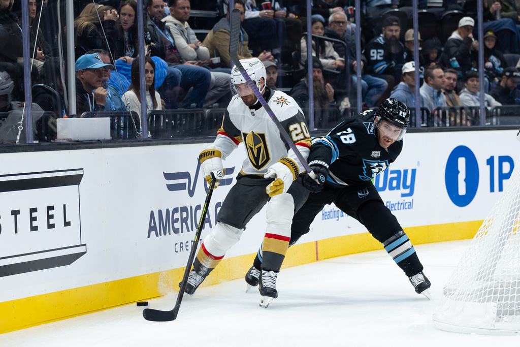 Utah Mammoth defenseman Ian Cole (28) and Vegas Golden Knights left wing Brandon Saad (20) battle for the puck during the first period of an NHL hockey game, Monday, Nov. 24, 2025, in Salt Lake City. (AP Photo/Anna Fuder)