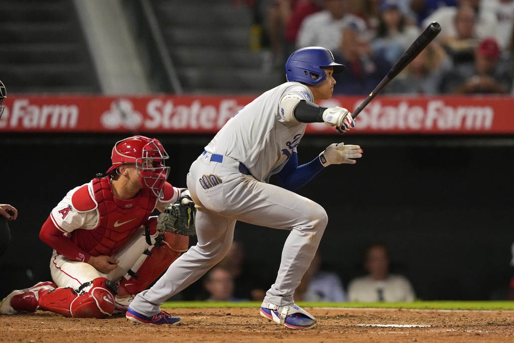 Los Angeles Dodgers' Shohei Ohtani, right, hits into a triple play as Los Angeles Angels catcher Logan O'Hoppe watches during the sixth inning of a baseball game Tuesday, Aug. 12, 2025, in Anaheim, Calif. (AP Photo/Mark J. Terrill)
