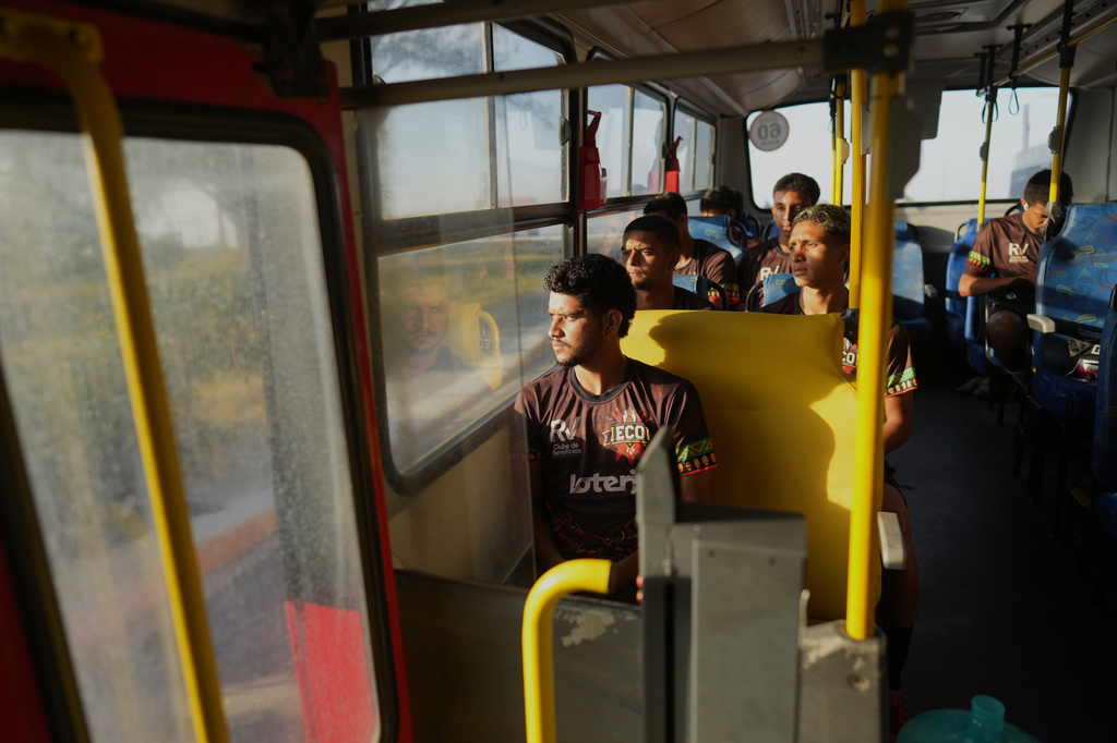 Players of Originarios, a new soccer team in Rio's fifth division made up exclusively of Indigenous players, ride a bus to practice in Marica, Brazil, Tuesday, April 28, 2026. (AP Photo/Silvia Izquierdo)