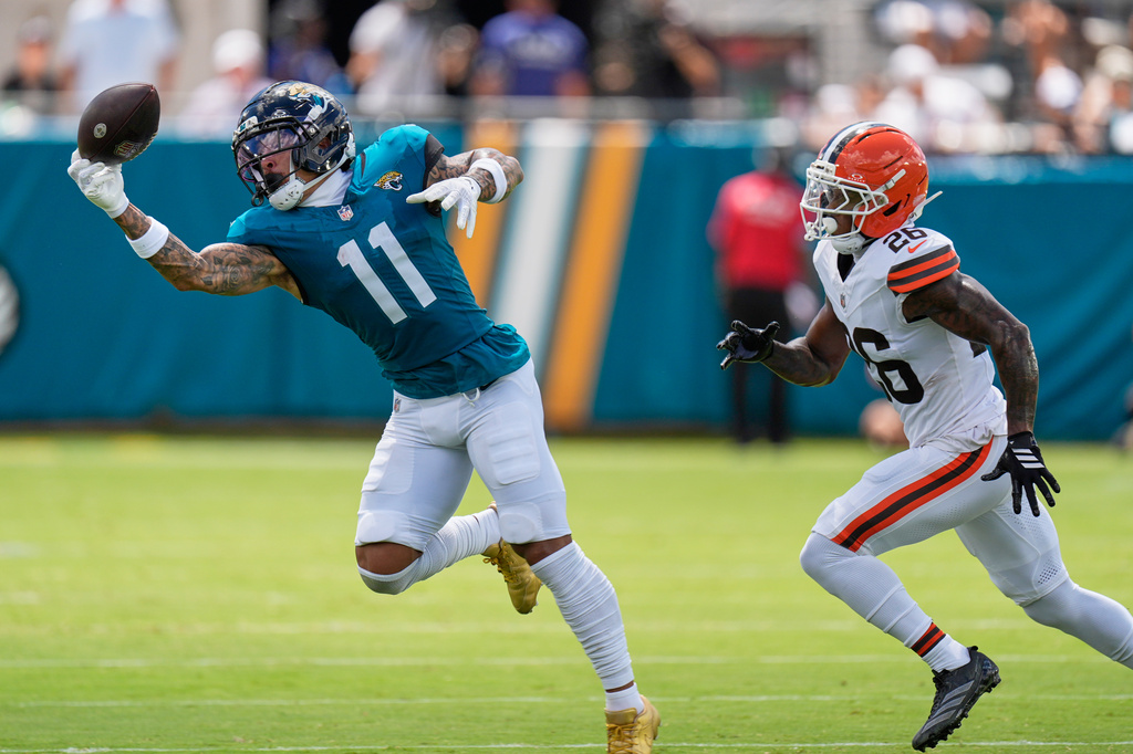 Jacksonville Jaguars wide receiver Parker Washington (11) catches a pass in front of Cleveland Browns cornerback Myles Harden (26) in the first Parker Washington, -cb26=half of an NFL football game, Sunday, Sept. 13, 2026, in Jacksonville. (AP Photo/Mike Stewart)