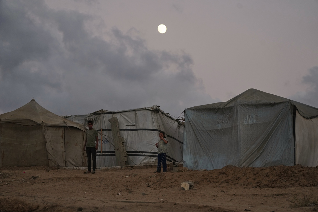 Displaced Palestinians kids stand by a makeshift tent camp along the shore of Nuseirat, central Gaza Strip, Sunday, October 5, 2025.(AP Photo/Abdel Kareem Hana)