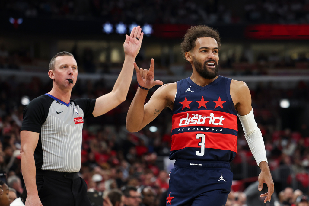 Washington Wizards guard Trae Young (3) gestures as the referee, left, gestures after making a three point basket during the first quarter of an NBA basketball game against the Chicago Bulls, Saturday, Oct. 24, 2026, in Chicago. (AP Photo/Jessie Alcheh)
