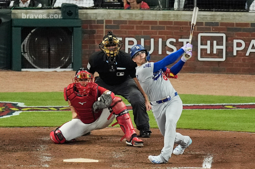 Los Angeles Dodgers' Enrique Hern&aacute;ndez follows through on a two-run home run as Atlanta Braves catcher Drake Baldwin (30) and umpire James Hoye look on during the fourth inning in Game 3 of baseball's National League Division Series, Tuesday, Oct. 6, 2026, in Atlanta. (AP Photo/Mike Stewart)