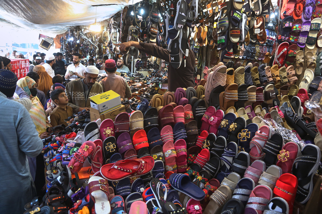 A family browses footwear at a local market for the upcoming Eid al-Fitr celebrations, which marks the end of the Islamic holy month of Ramadan in Peshawar, Pakistan, Tuesday, March 17, 2026. (AP Photo/Muhammad Sajjad)