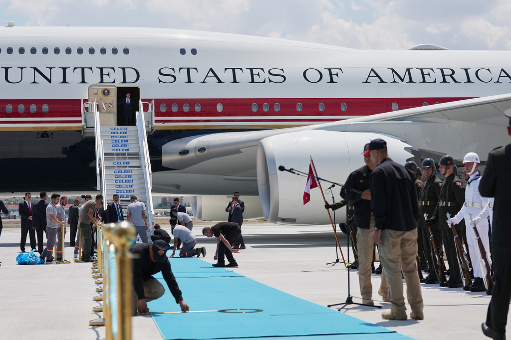 Staff lay a carpet on the tarmac before President Donald Trump exits Air Force One upon arriving for the NATO summit in Ankara, Turkey, Tuesday, July 7, 2026. (AP Photo/Alex Brandon)