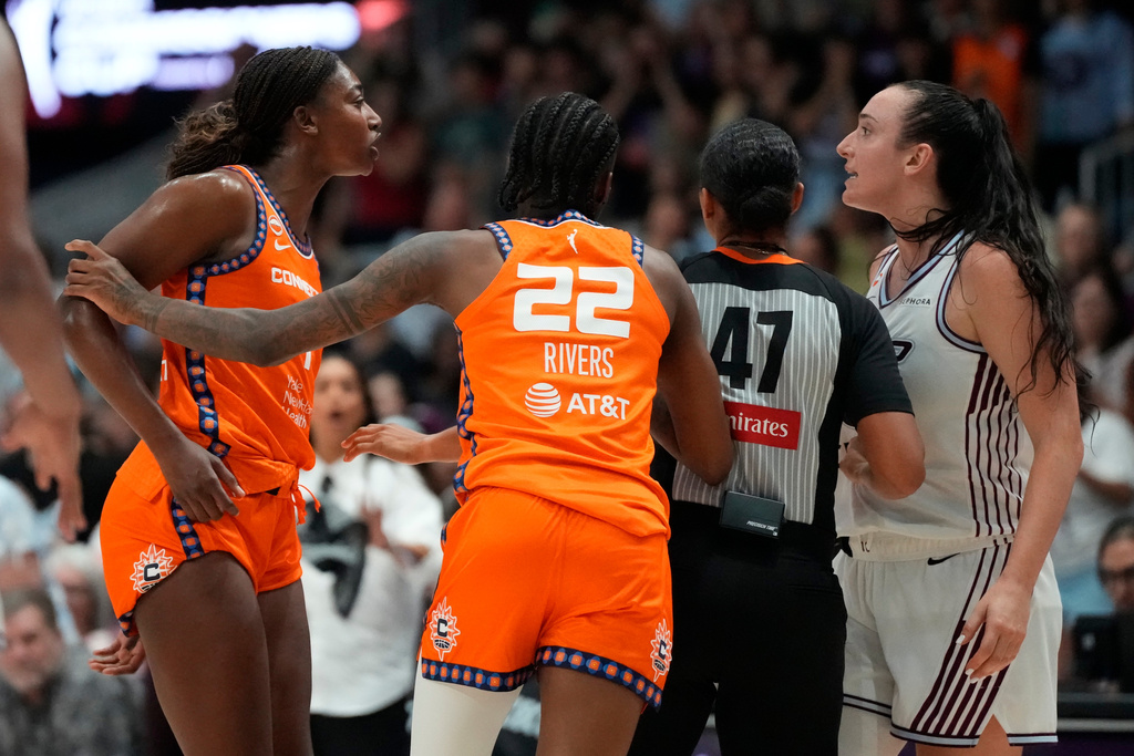 Connecticut Sun's Saniya Rivers (22) and a referee pull apart forward Diamond Miller (1) and Toronto Tempo's Marina Mabrey (3) as they have a scuffle during overtime WNBA action in Toronto, Ontario, Wednesday, June 10, 2026. (Frank Gunn/The Canadian Press via AP)