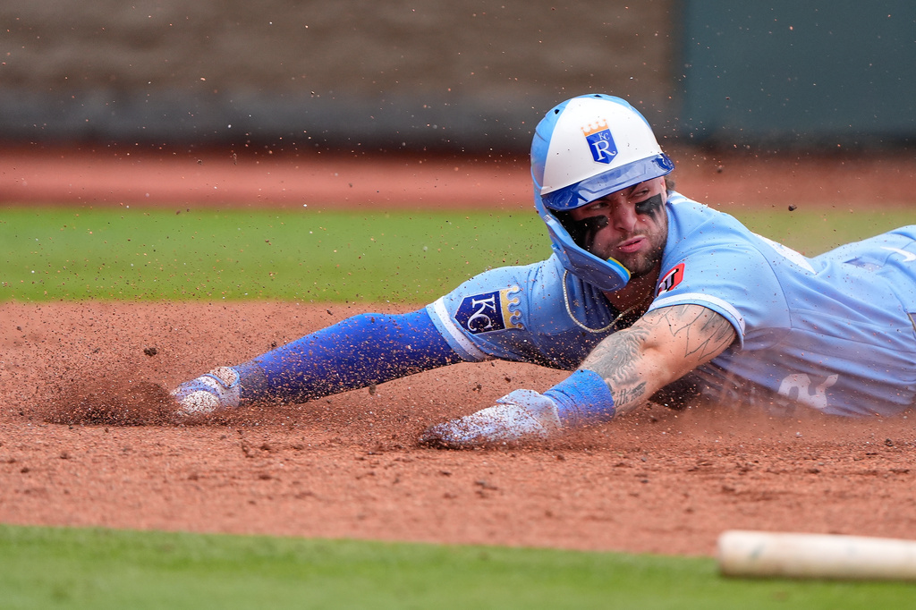 Kansas City Royals' Carter Jensen slides home to score on a single by Isaac Collins during the sixth inning of a baseball game against the Seattle Mariners, Saturday, May 23, 2026, in Kansas City, Mo. (AP Photo/Charlie Riedel)