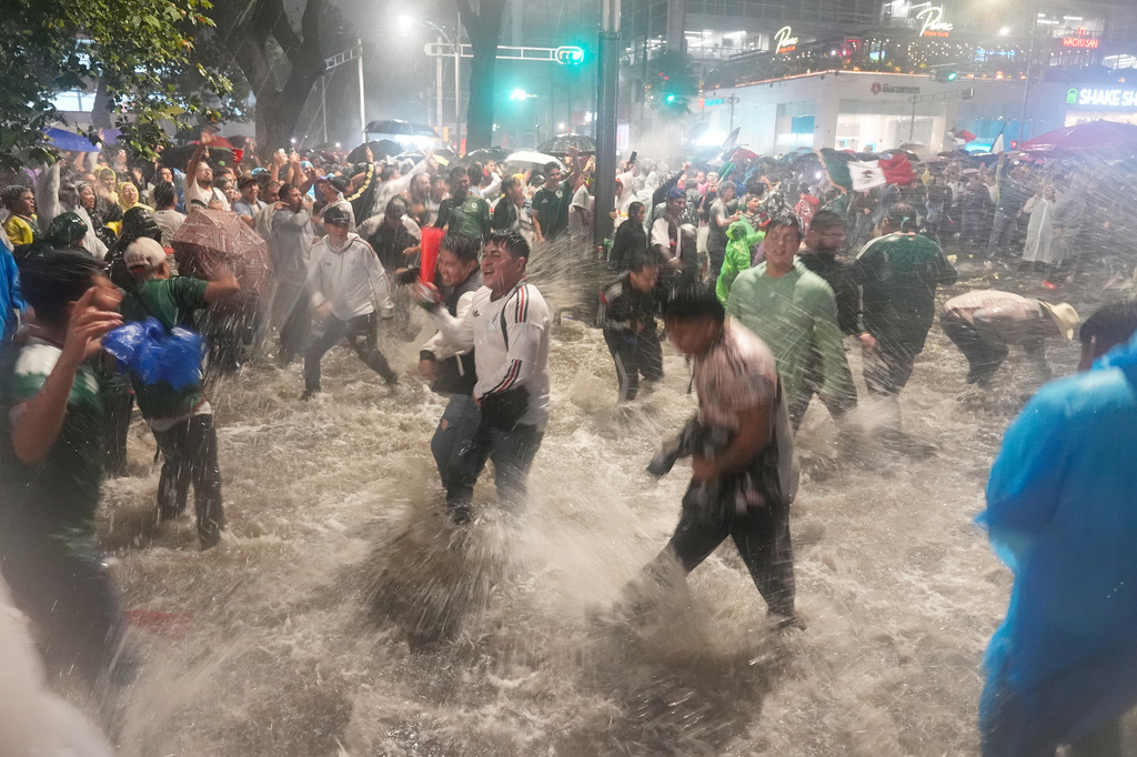 FILE - Fans celebrate under the rain after Mexico defeated Czechia in a World Cup Group A soccer match, in Mexico City, June 24, 2026. (AP Photo/Marco Ugarte, File)