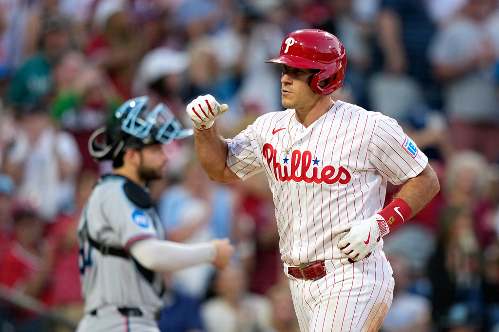 Philadelphia Phillies' J.T. Realmuto, right, reacts after hitting a two-run home run against Miami Marlins pitcher Ryan Gusto during the fifth inning of a baseball game Monday, June 15, 2026, in Philadelphia. (AP Photo/Matt Slocum)